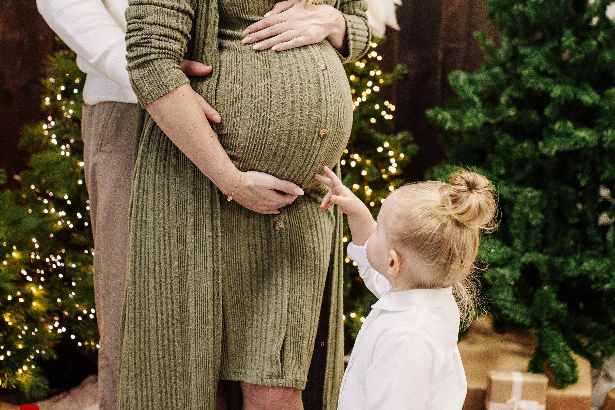 Kleines Mädchen fasst den Schwangerschaftsbauch ihrer Mutter an – Familienfotografie Julia Kippes